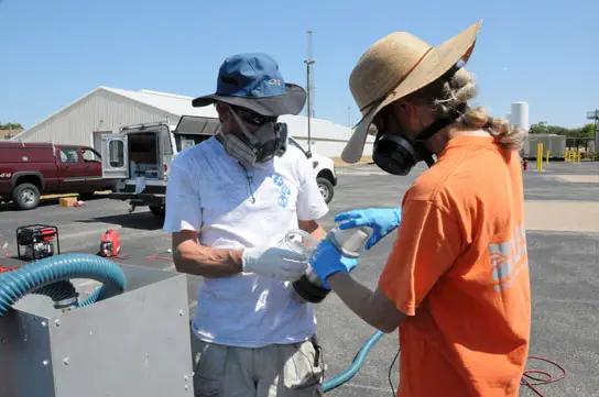USGS scientists prepare a sampler used to measure emission of polycyclic aromatic carbons (PAHs) into the air USGS scientists prepare a sampler used to measure emission of polycyclic aromatic carbons (PAHs) into the air