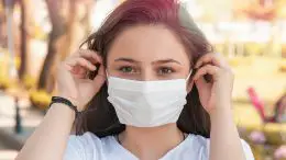 Woman Putting on COVID Face Mask